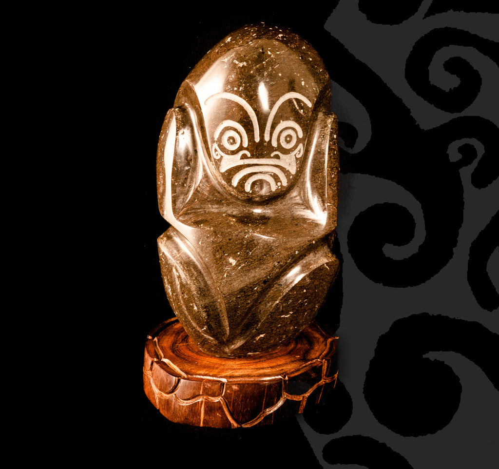 Tiki Sculpted in Dark Stone on a Wooden Pedestal